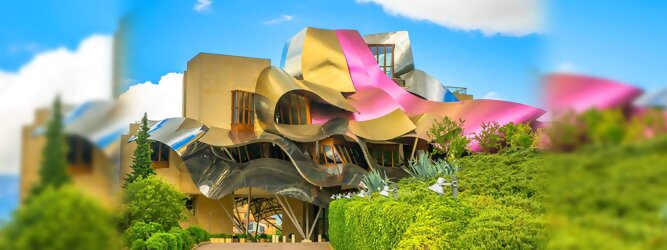 Trip Voucher Reisetipps - Marqués de Riscal Design Hotel, Bilbao, Elciego, Spanien. Fantastisch galaktisch, unverkennbar ein Werk von Frank O. Gehry. Inmitten idyllischer Weinberge in der Rioja Region des Baskenlandes, bezaubert das schimmernde Bauobjekt mit einer Struktur bunter, edel glänzender verflochtener Metallbänder. Glanz im Baskenland - Es muss etwas ganz Besonderes sein. Emotional, zukunftsweisend, einzigartig. Denn in dieser Region, etwa 133 km südlich von Bilbao, sind Weingüter normalerweise nicht für die Öffentlichkeit zugänglich.